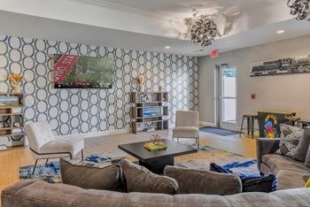 a living room with couches and chairs and a tv